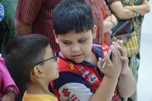 Children playing together with a smartphone outdoors in Kolkata
