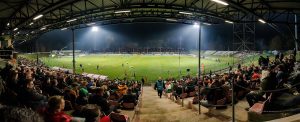 A packed stadium under floodlights during a night match